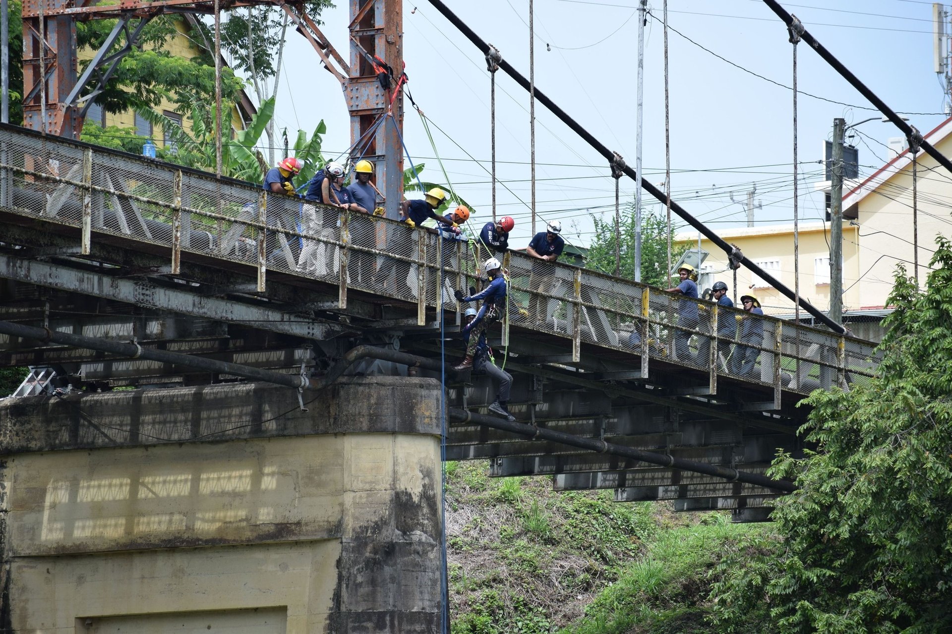 Trek Medics International Photo of ten people on a bridge helping two people hanging on the bridge