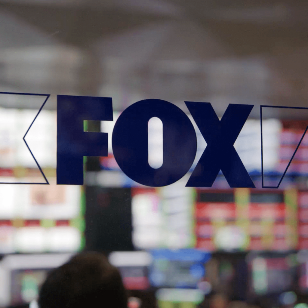FOX logo on glass overlooking operations control room.
